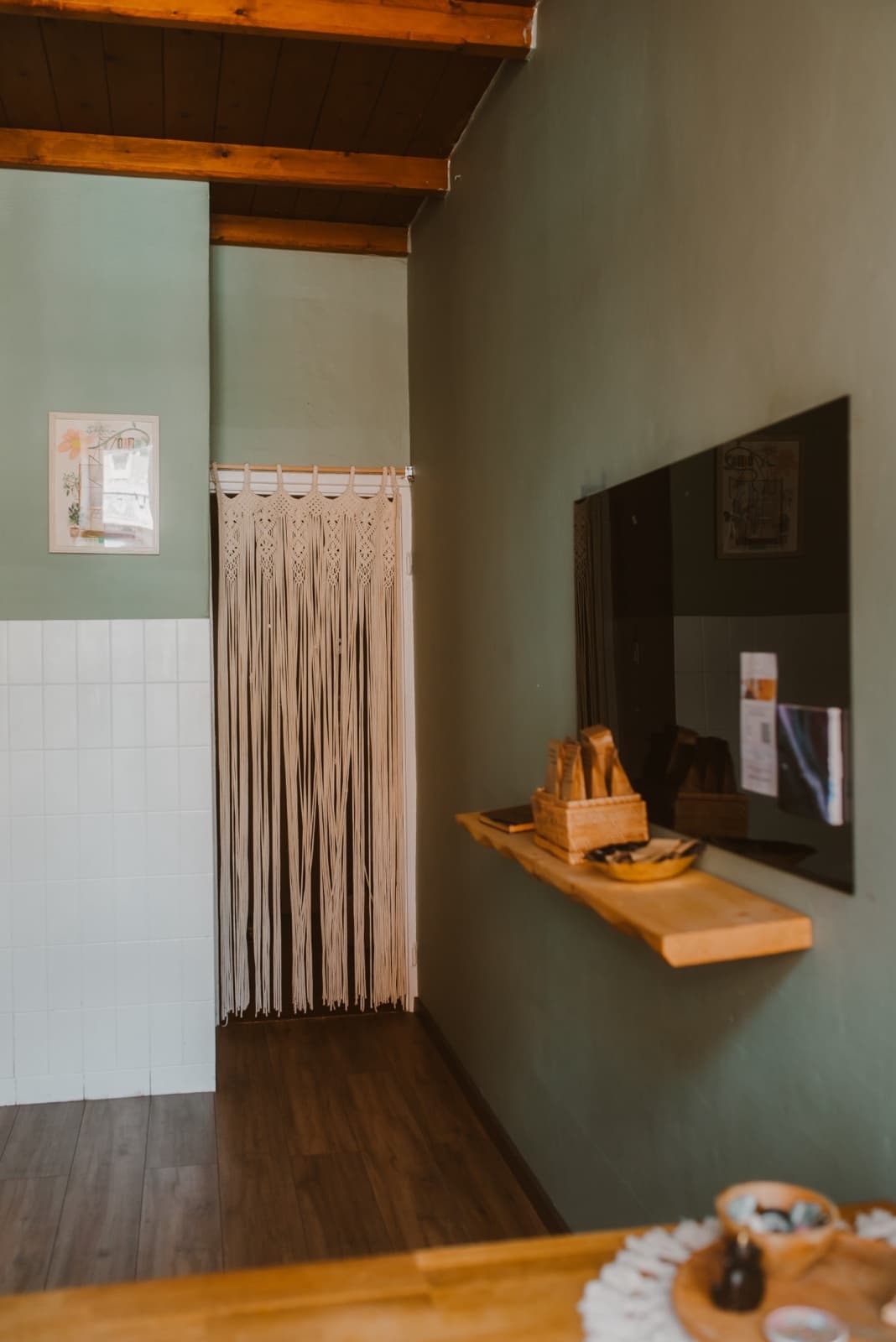 The green room with a macramé curtain and wooden beams