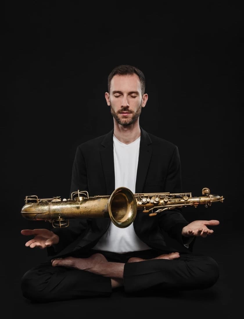 Sławomir Pezda with his saxophone, sitting in meditation