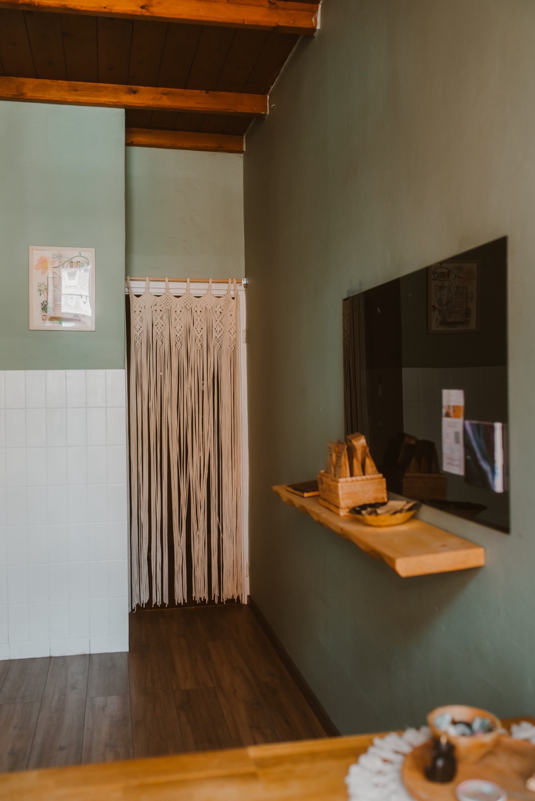 The green room with a macramé curtain and wooden beams